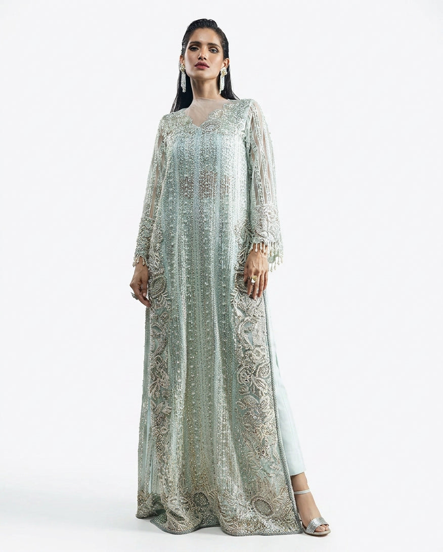 Woman wearing an Aqua embroidered Net suit with raw silk trousers