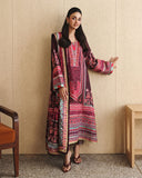 Woman wearing deep purple printed raw silk suit gesturing beside a wood-panelled wall