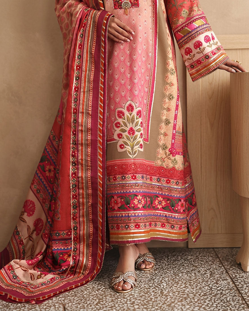 Close-up of embroidered neckline and sleeve cuff on peach printed raw silk suit