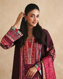 Close-up of embroidered neckline and printed sleeve on deep purple raw silk shirt