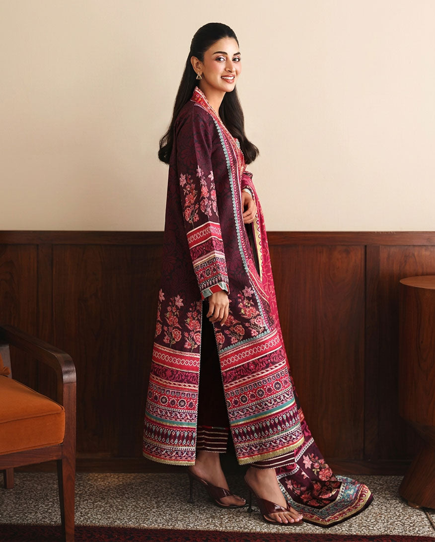 Side view of deep purple printed raw silk suit with pink embroidered dupatta draped over shoulder