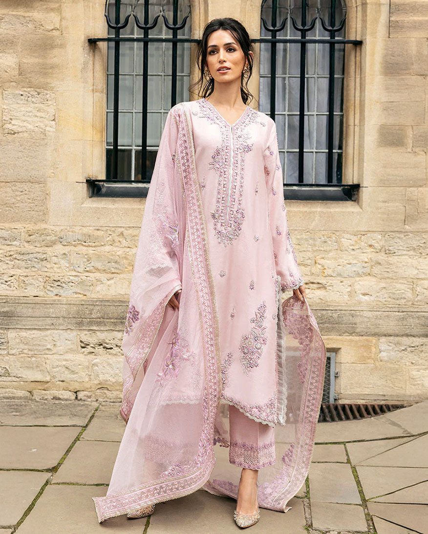 Woman wearing Astrid pink raw silk suit with resham embroidery and cutwork lace border dupatta