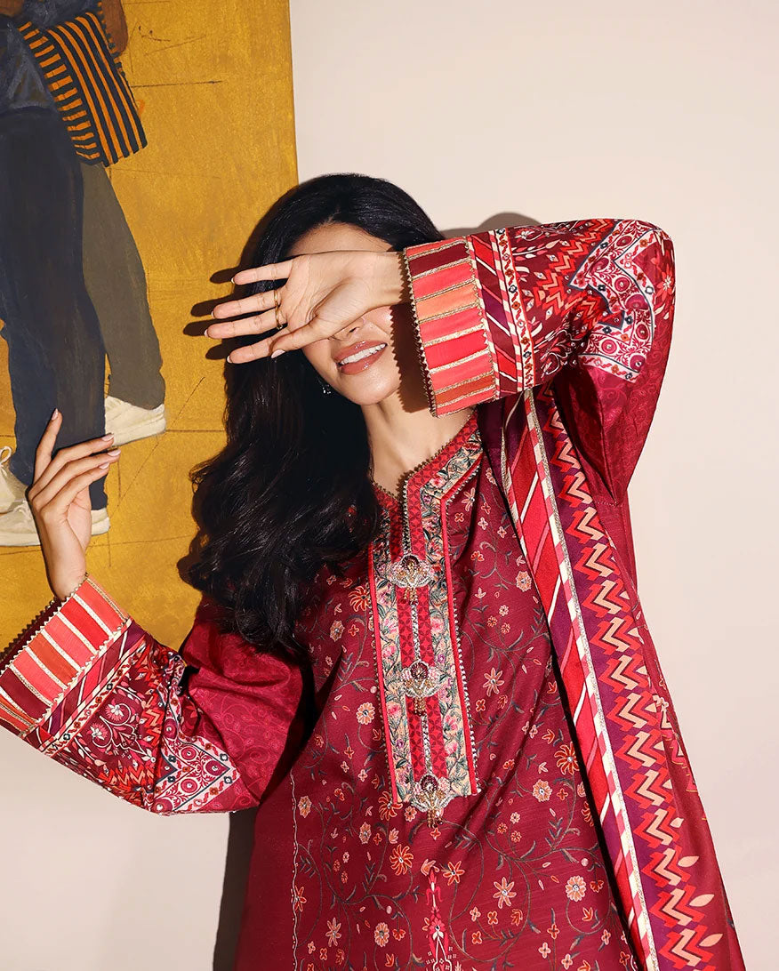 Close-up of striped sleeve cuff on red printed raw silk suit, playful pose covering eye