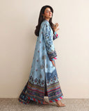 Side view of blue printed raw silk suit walking, showing embroidered hem border