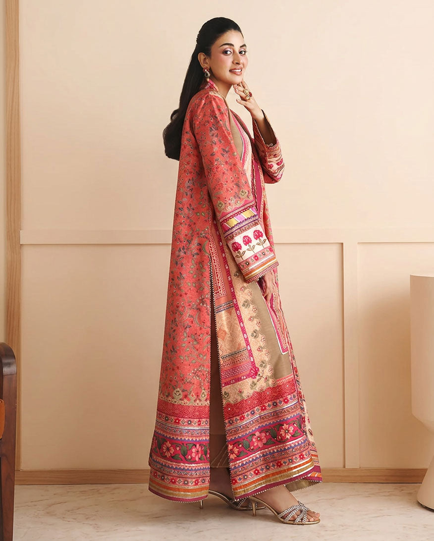Side view of peach printed raw silk suit with hand at chin, showing sleeve embroidery