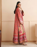 Side view of peach printed raw silk suit with hand at chin, showing sleeve embroidery