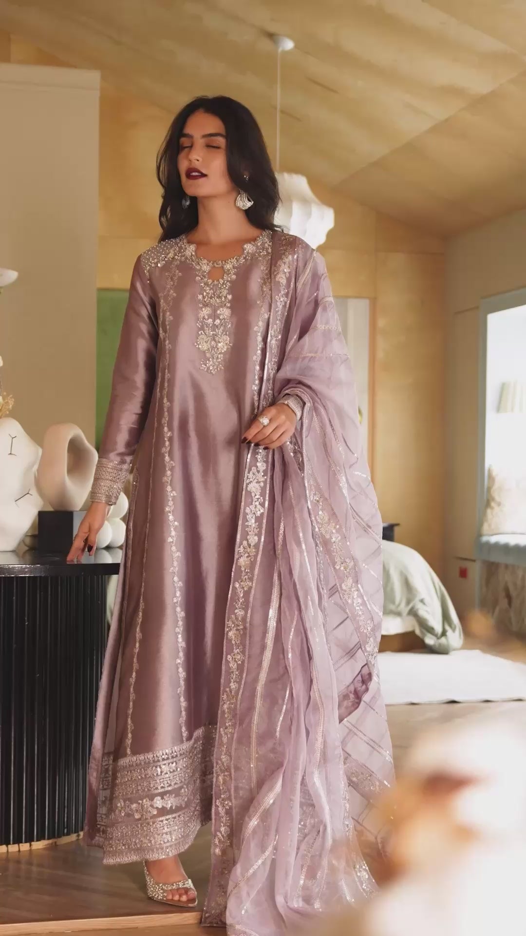 Woman wearing a dusty lilac embellished kurta with gold embroidered hem and sequin dupatta, styled in a plush bedroom setting, Zarminay | Luxury Pret collection