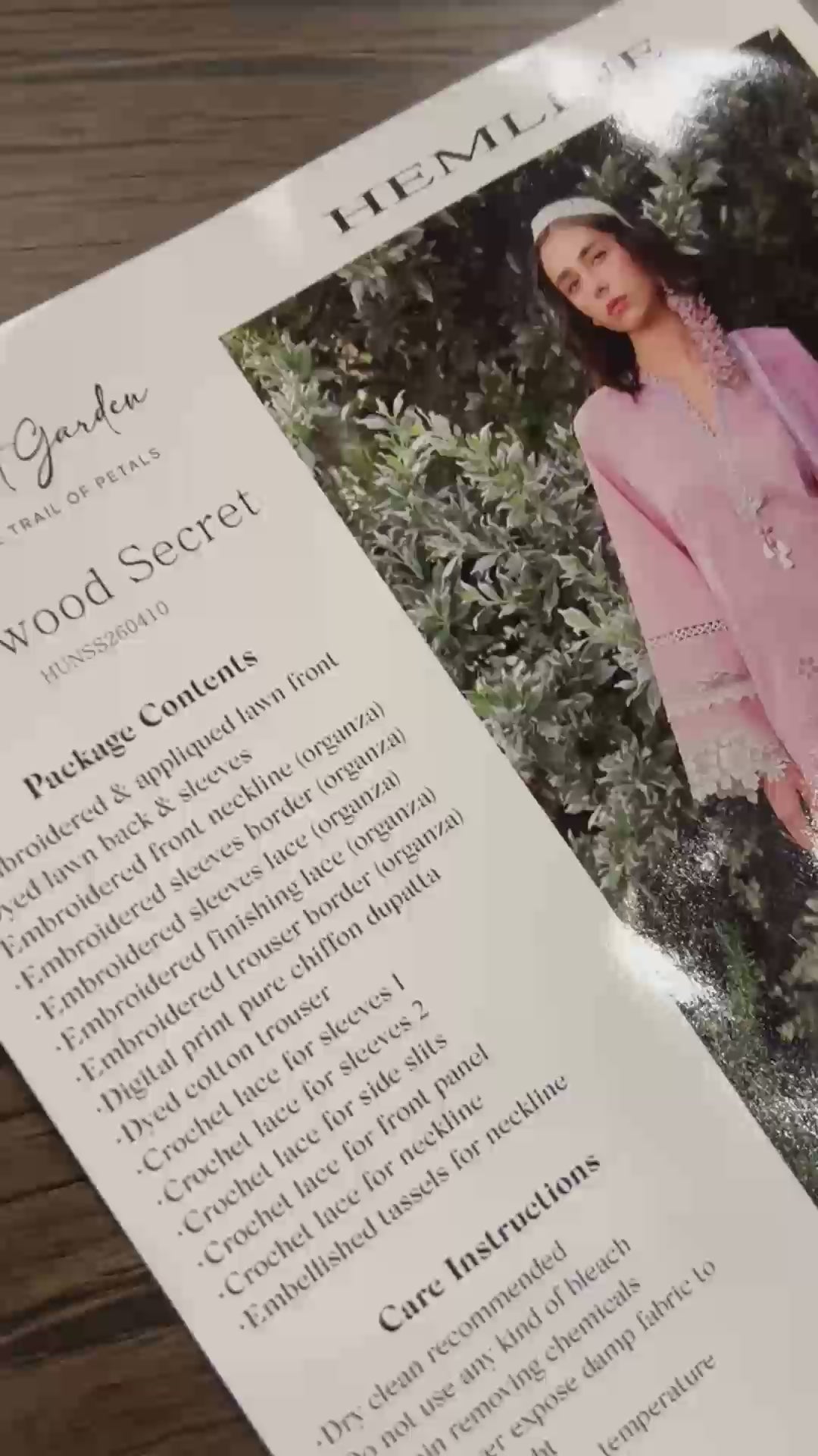 Flat-lay unboxing of light pink unstitched lawn suit fabric with lace appliques, Secret Garden collection