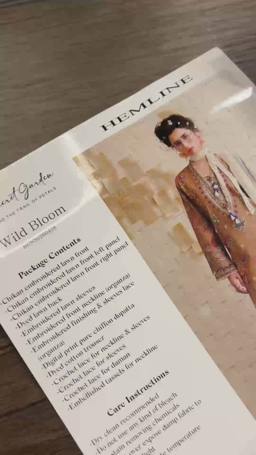 Flat-lay unboxing of coffee embroidered lawn suit fabric with lace trims, Secret Garden collection