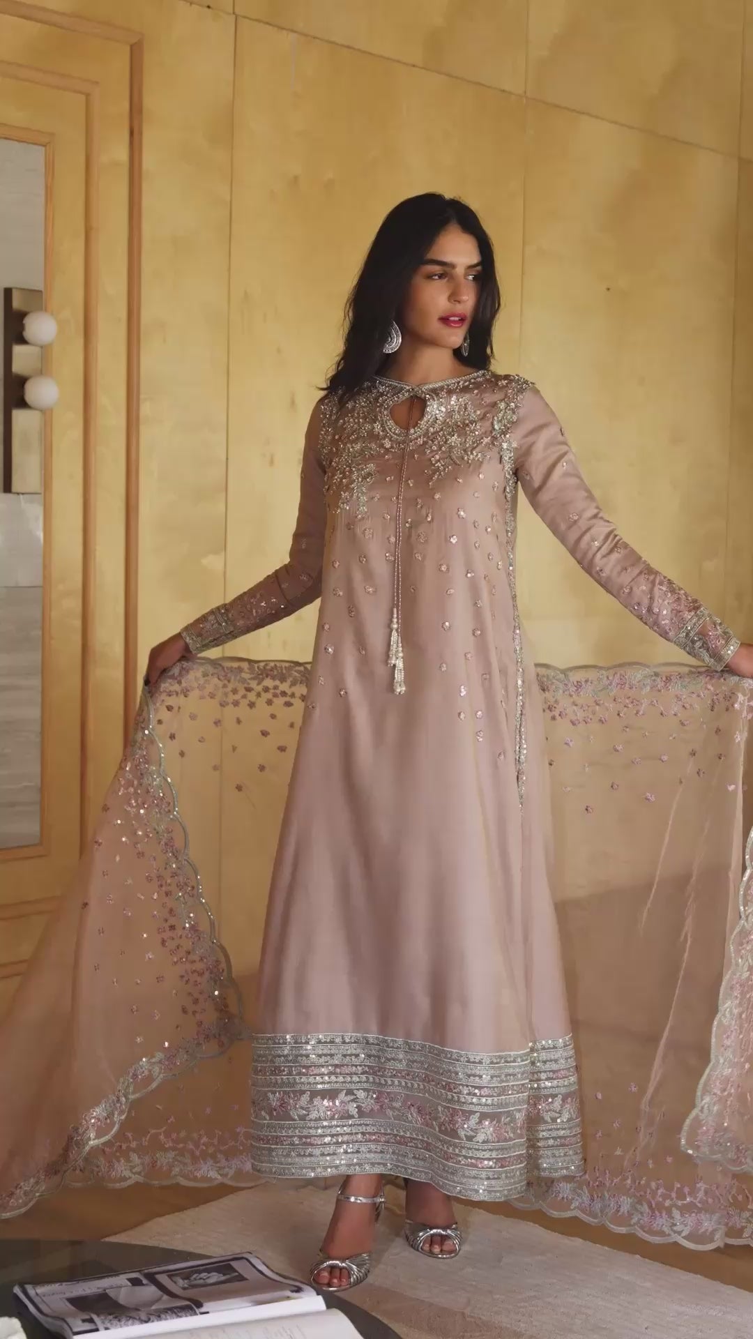 Woman wearing a nude pink embellished kurta with sheer sequin floral embroidery and keyhole neckline, styled against a golden-paneled interior, Zarminay | Luxury Pret collection
