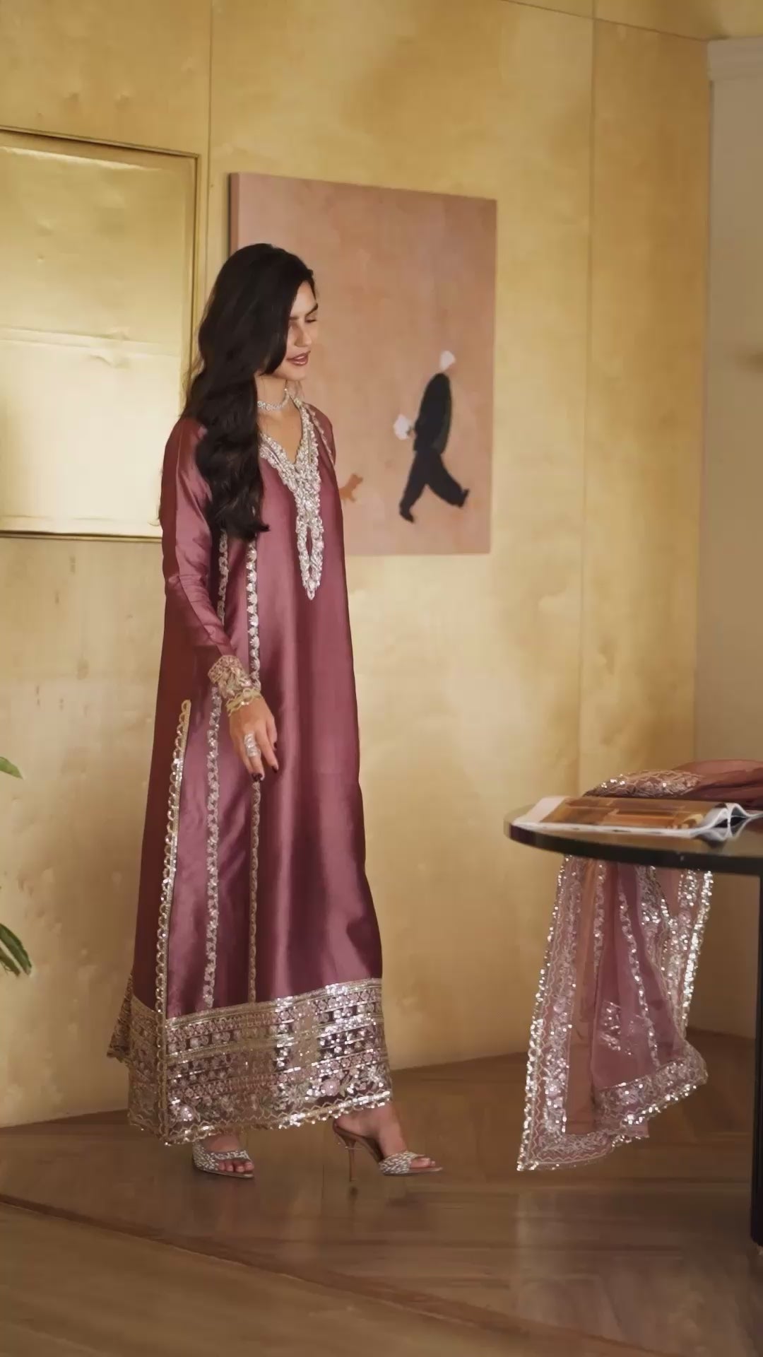 Woman wearing a deep mauve satin kurta with a silver sequin embroidered neckline and hem, styled against a golden-paneled interior, Zarminay | Luxury Pret collection